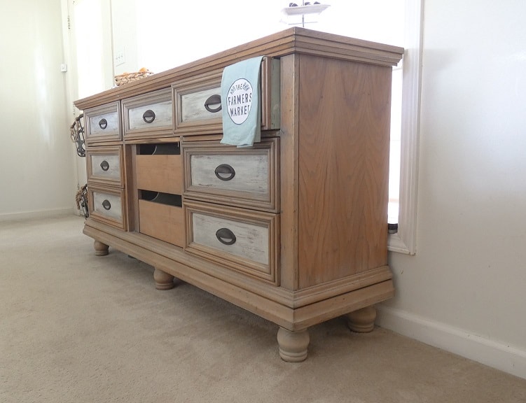 An old dresser with drawers in a room.