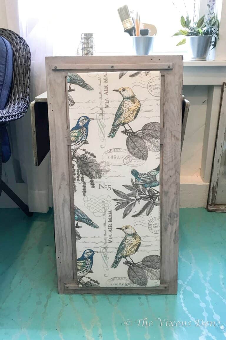 A wooden cabinet with a bird print on it.