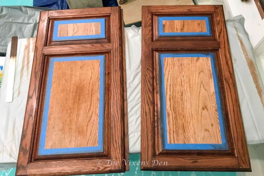 stained cabinet doors taped off in preparation for painting