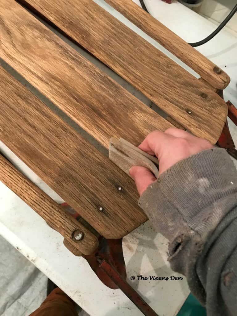 hand sanding the slats between the vintage sled bed