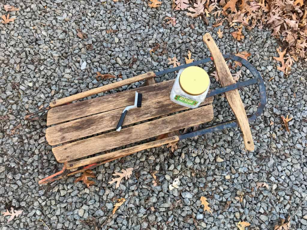 vintage sled staged with nylon bristled brush and a container of premixed white lightning