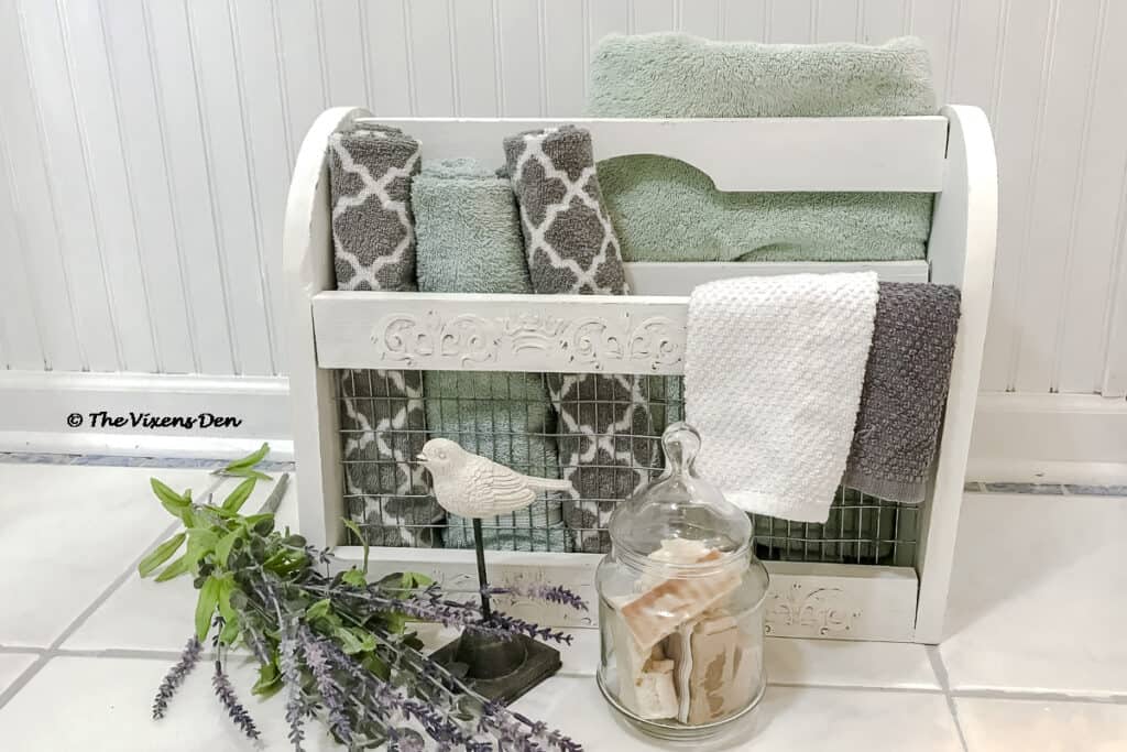 repurposed magazine rack staged as a towel caddy