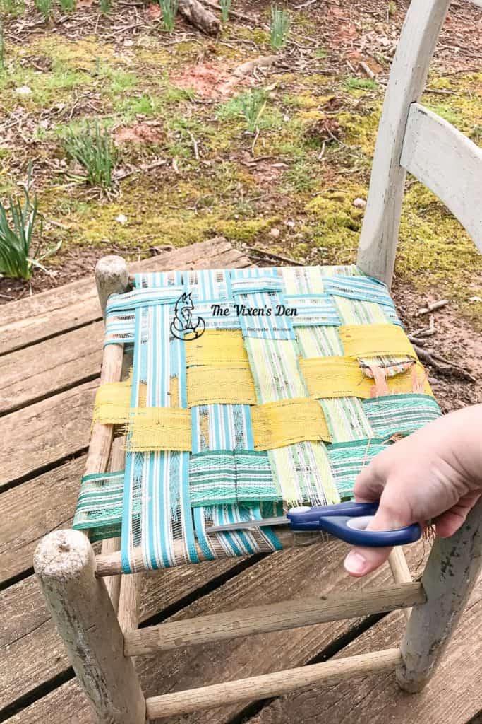 cutting the woven webbing seat off of a ladderback chair