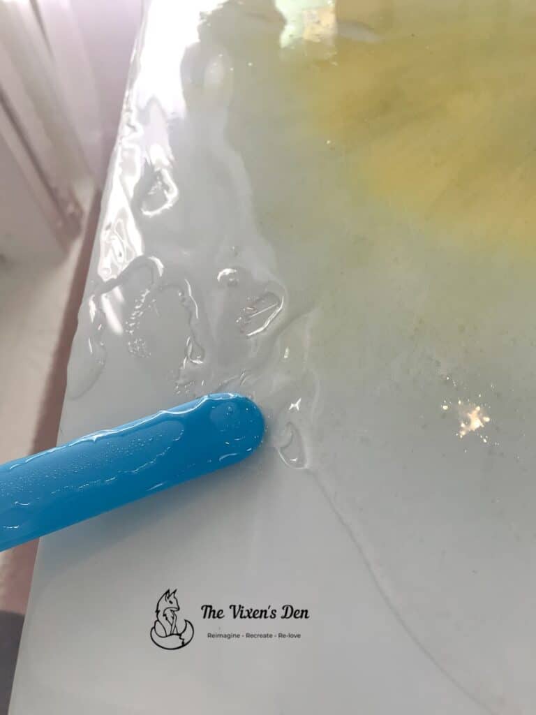 epoxy resin being spread on a table top with a silicone spatula-1-min