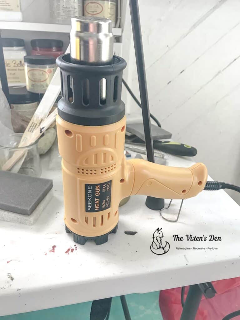 heat gun safely cooling with other tools and paint materials in the background-1-min