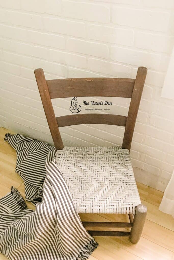 ladderback chair with woven seat and a striped throw-min