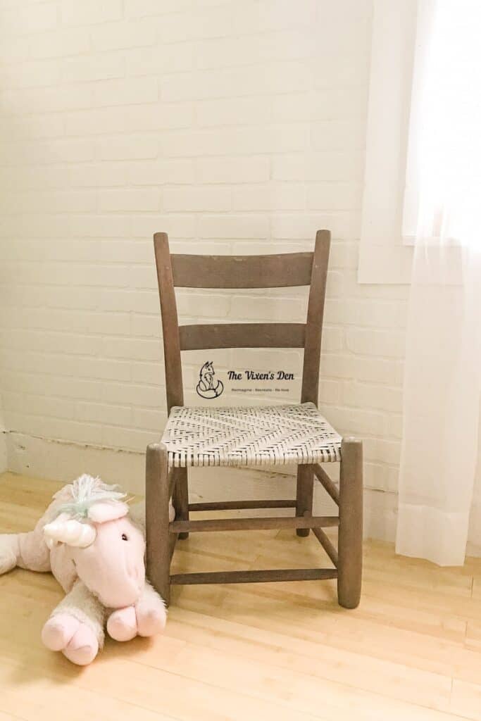 ladderback chair with a stuffed unicorn against the new faux brick staging wall -1-min