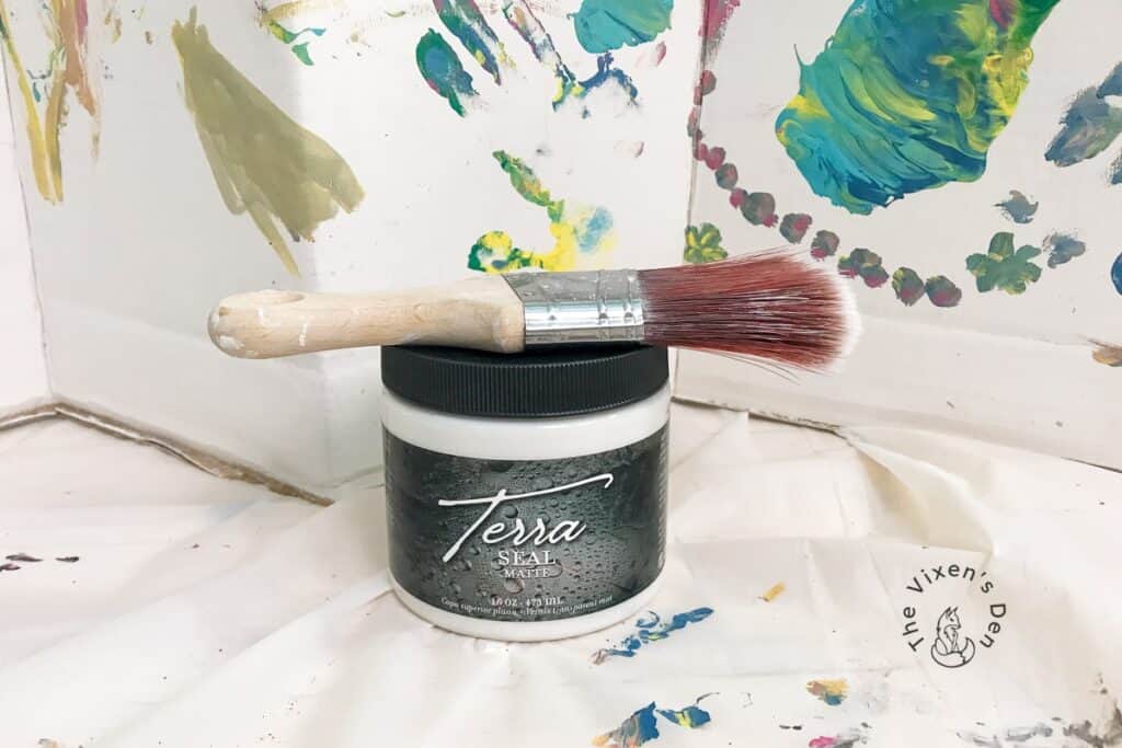 Jar of Terra Seal matte with a paintbrush laid on top