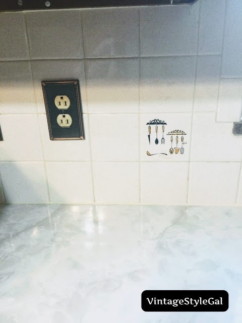 Old backsplash tile with utensils on it