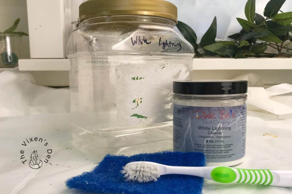 White Lightning Cleaner mixed in a jar with a toothbrush and a blue scrubber