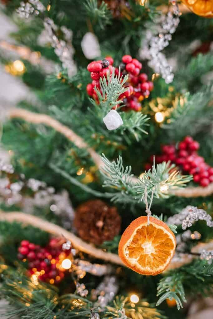 closeup of tabletop Christmas tree with dried clementine orange slice ornament and DIY white rock ornament