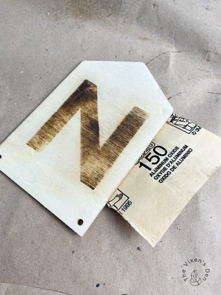Woodburned letter with 150 grit sandpaper