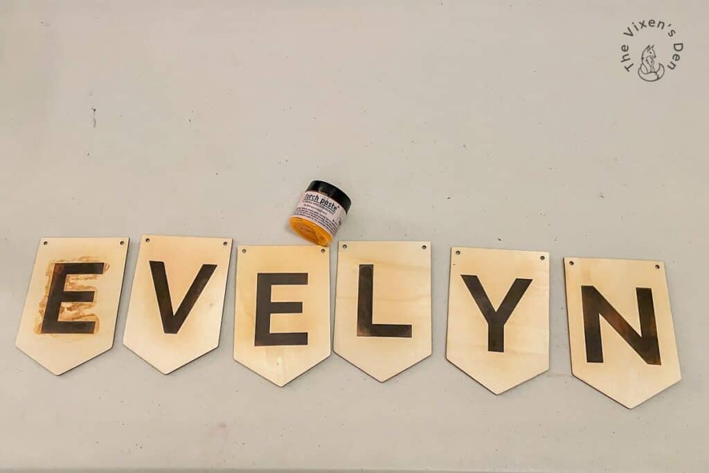 Woodburned name banner with a jar of torchpaste