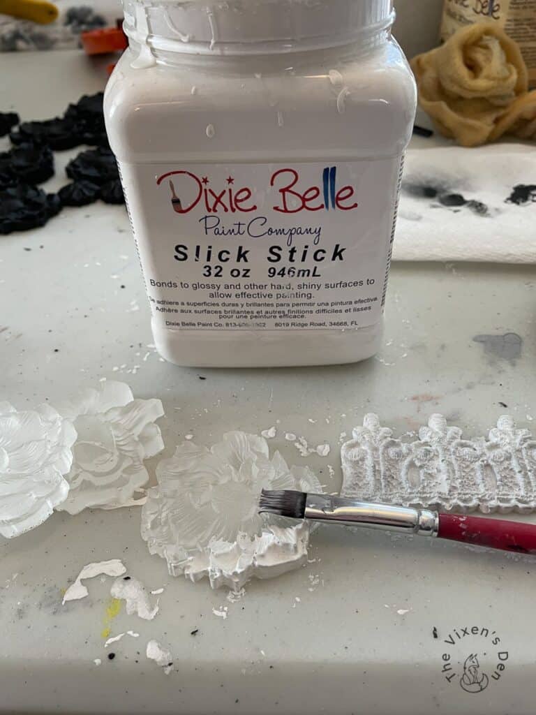 Slick stick with partially primed appliques and an artist brush