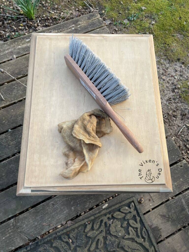 Soft dusting brush and tack cloth on freshly sanded table top