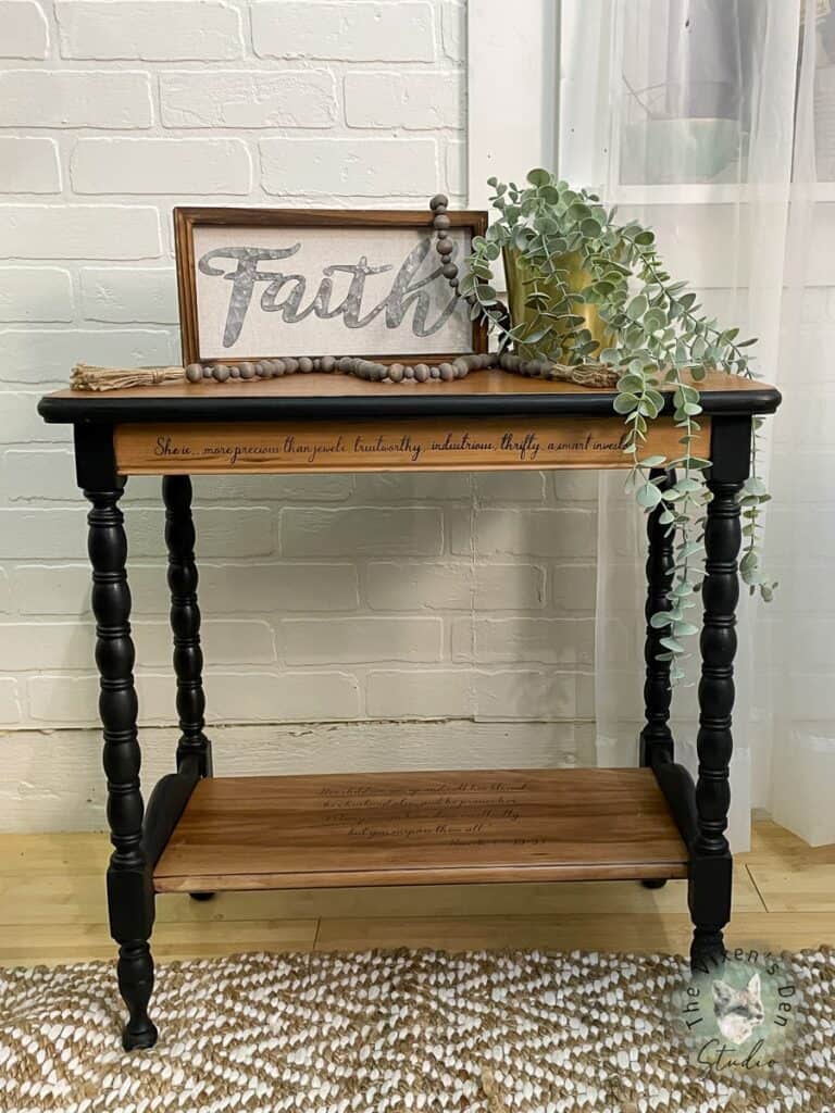 A black console table with a sign on it.