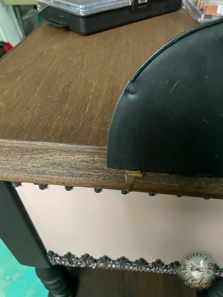 Scraping excess burn in wood filler side view