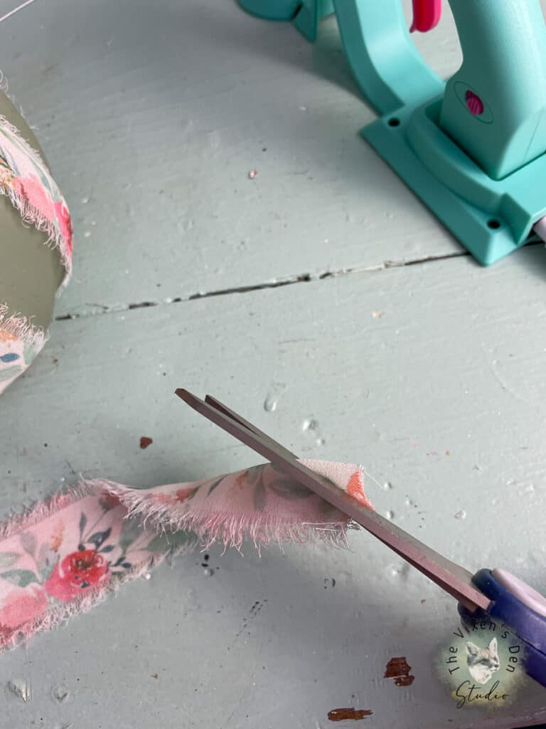 A pair of scissors on a table next to a piece of fabric.