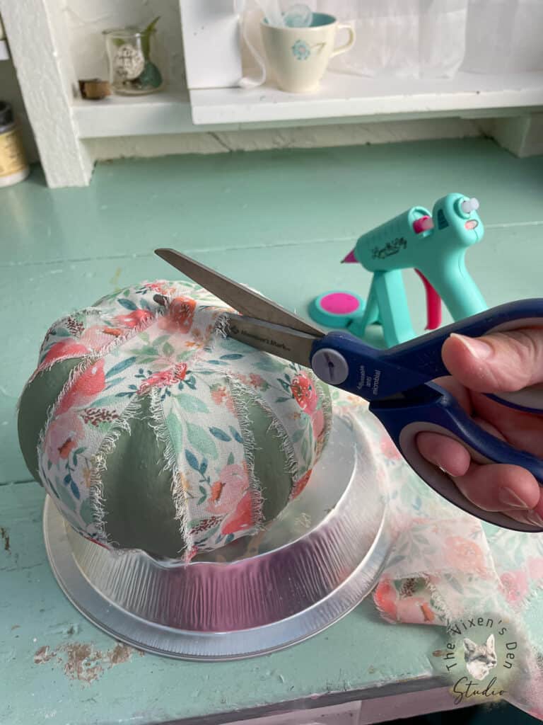 A person cutting fabric with a pair of scissors.