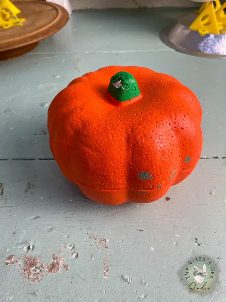 An orange pumpkin sits on top of a table.