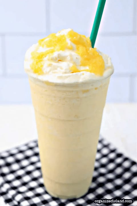A starbucks lemonade with whipped cream and a straw.