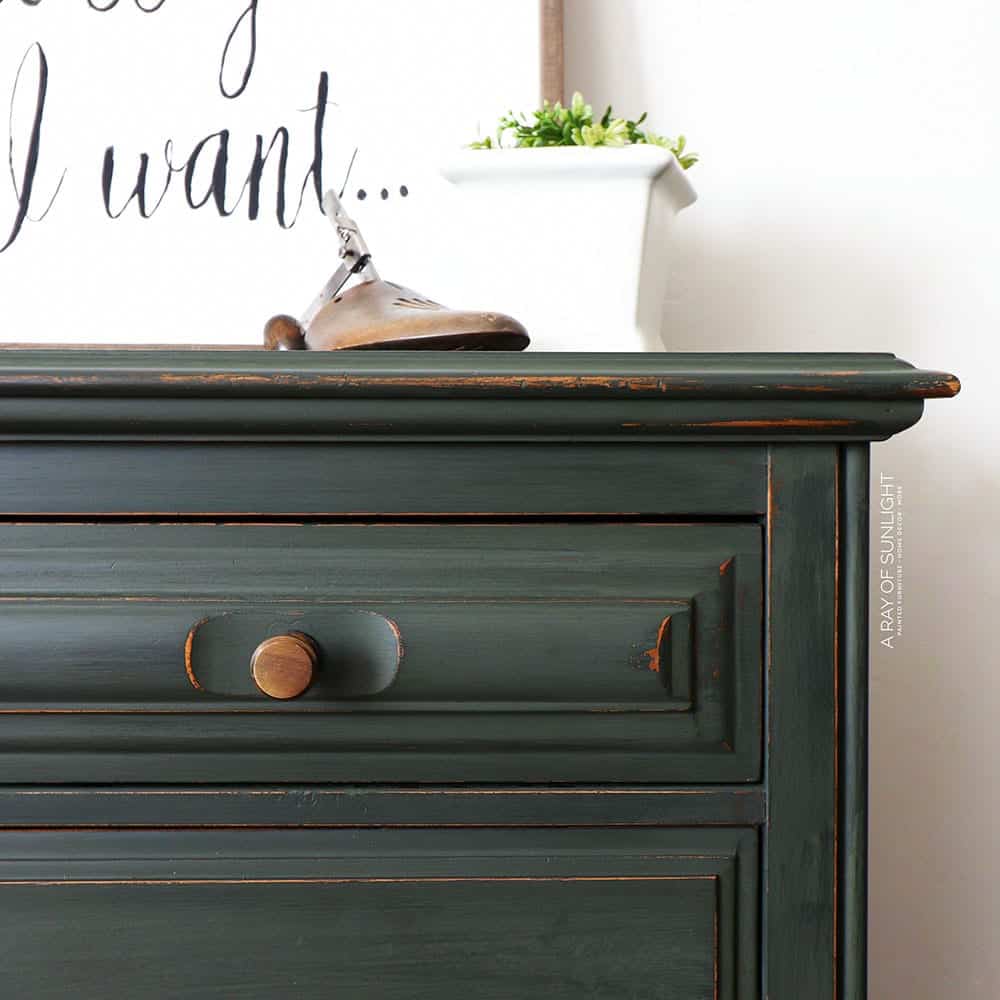 A green nightstand with a sign on it.