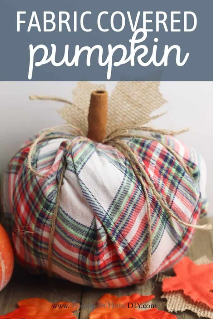 A plaid fabric covered pumpkin on a table.