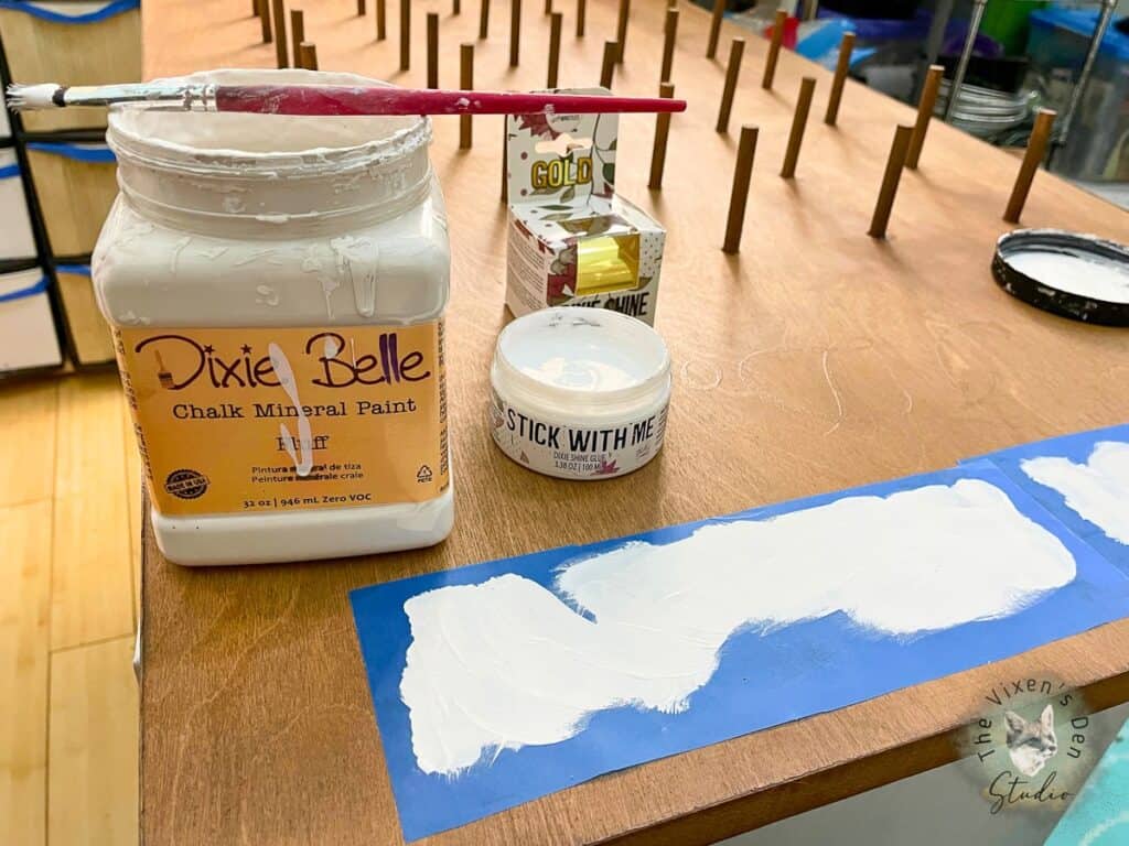A jar of paint and a brush on a table.
