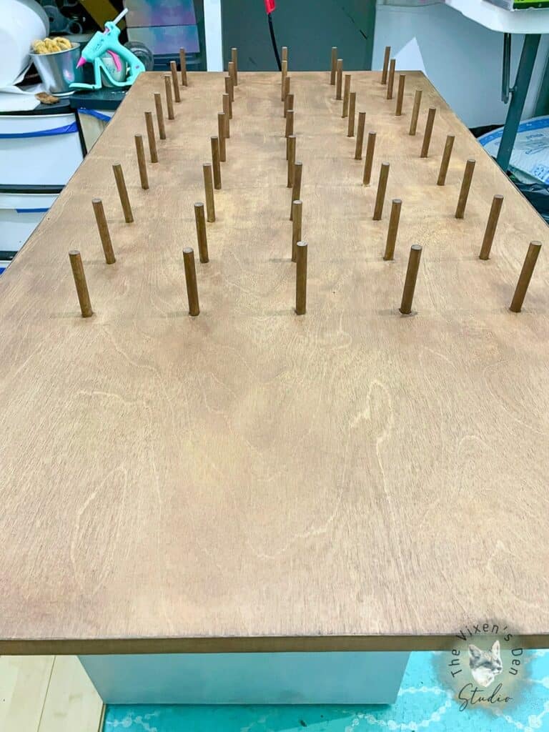 A wooden table with wooden pins on it.
