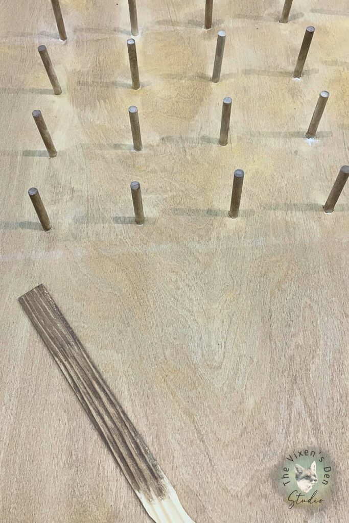 A wooden board with wooden pins on it.