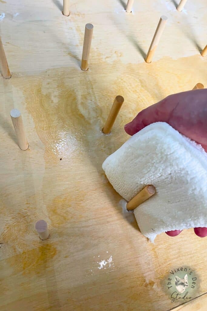 A person is using a cloth to clean a wooden table.