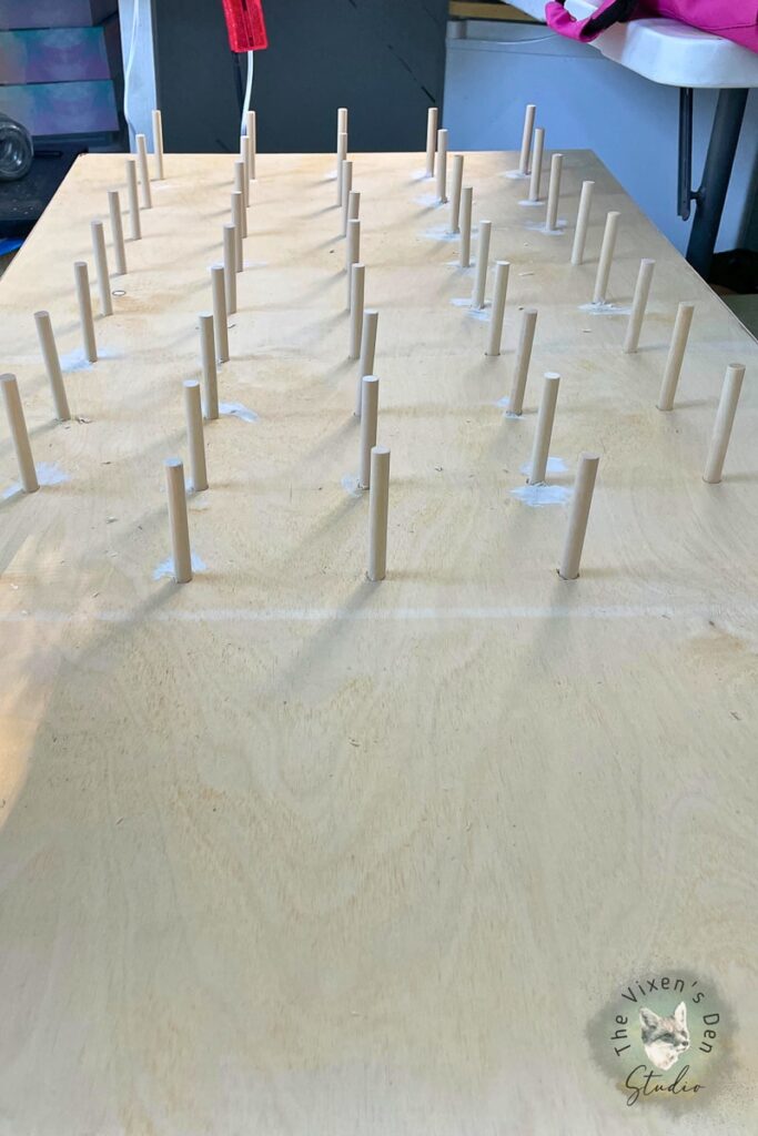 A wooden board with wooden pegs on it.