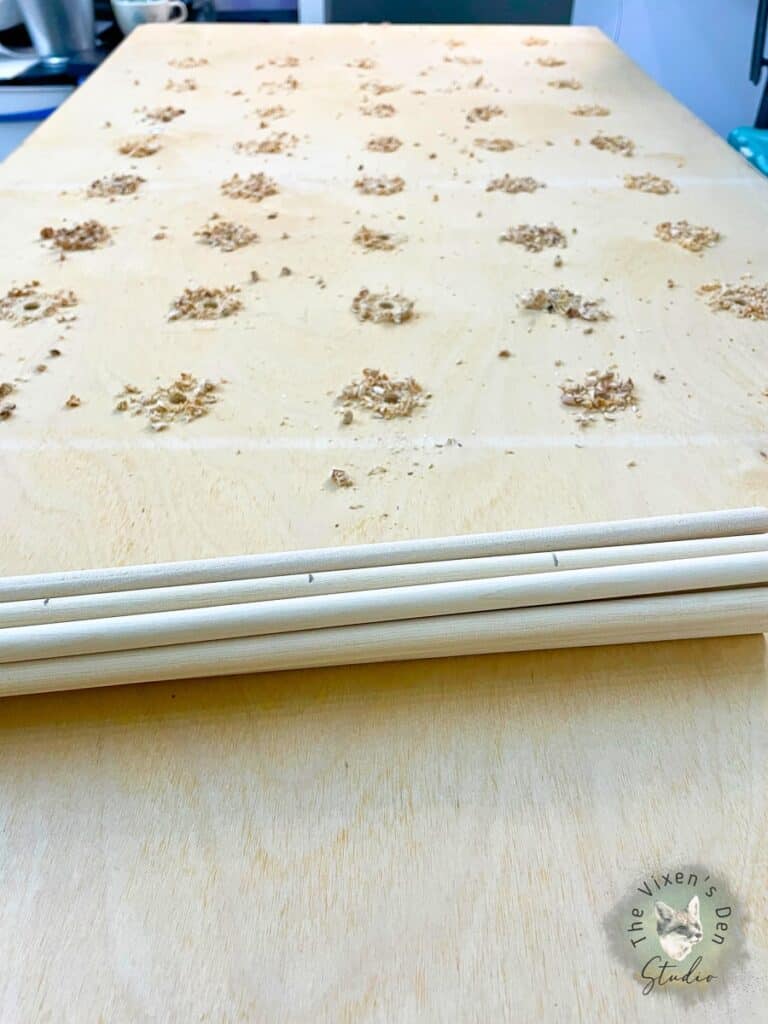 A wooden board with a bundle of wooden dowels on it.