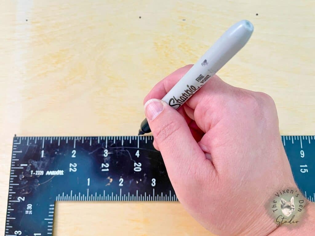 A person using a ruler to measure a piece of wood.