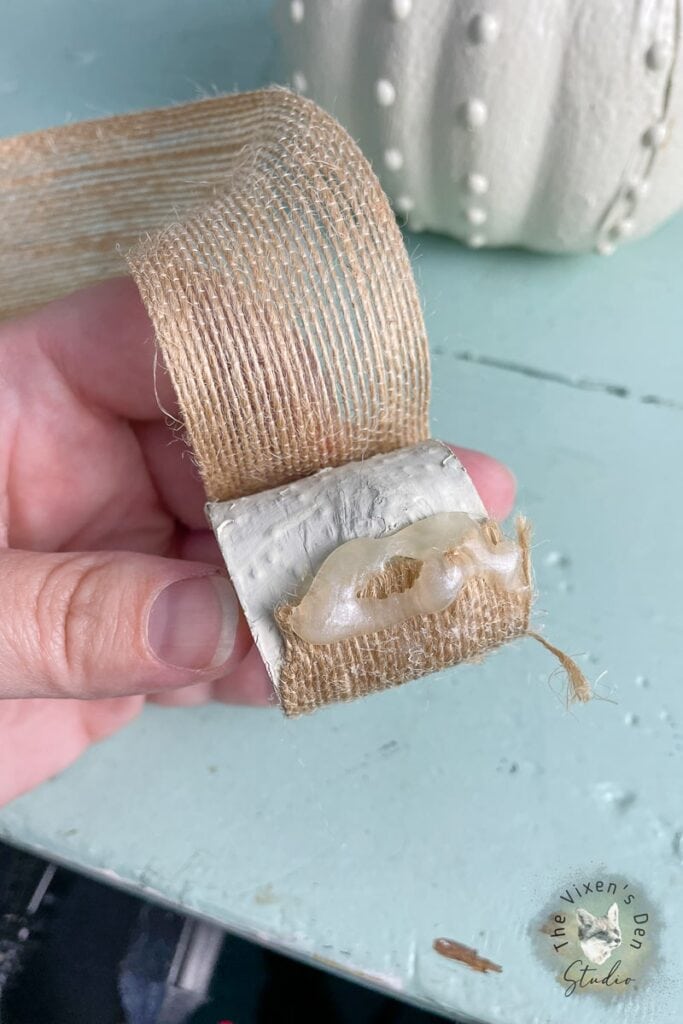 A person holding a piece of burlap on a table.