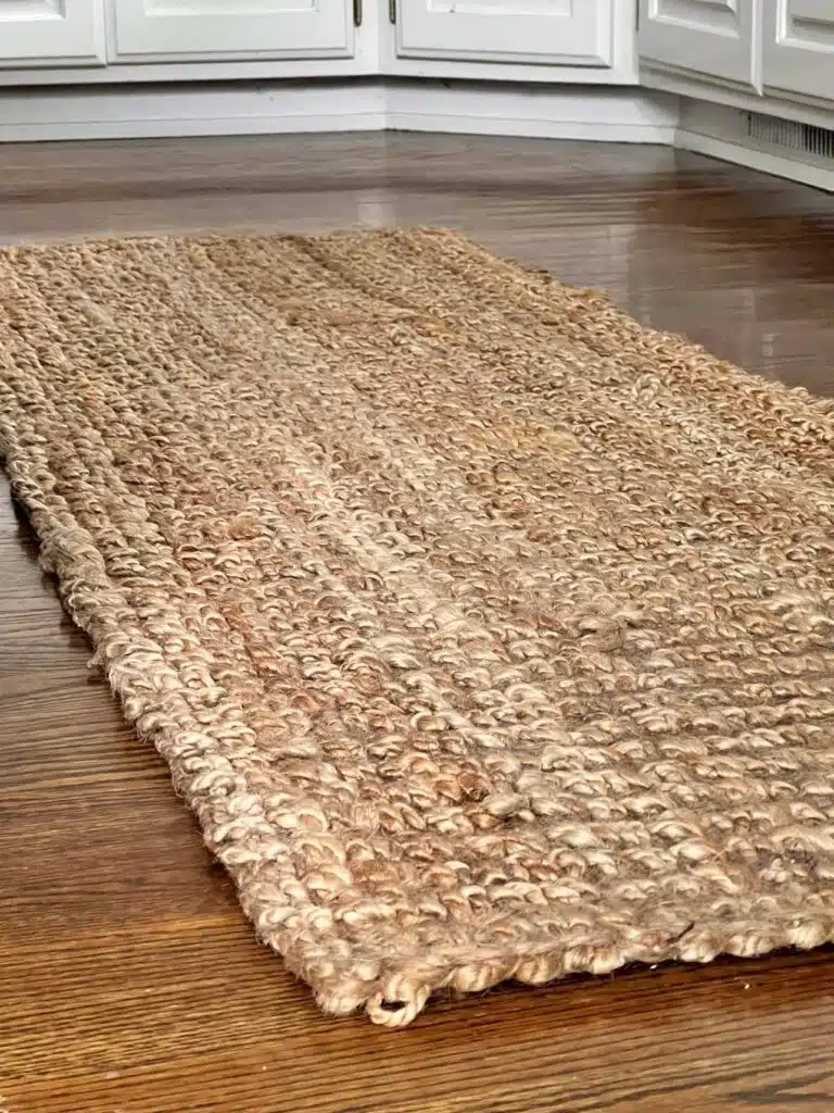 A jute rug on a wooden floor in a kitchen.