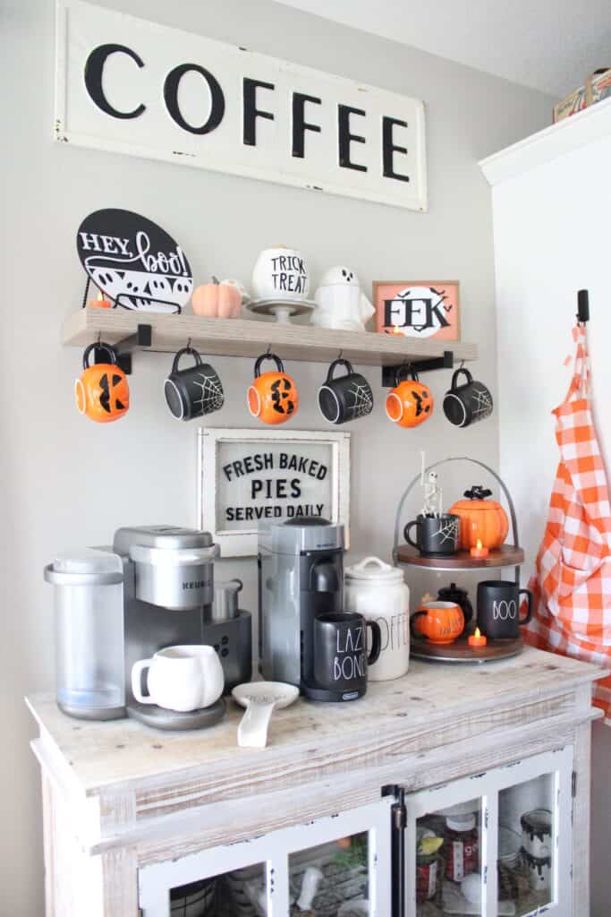 A kitchen with a coffee maker and pumpkins.