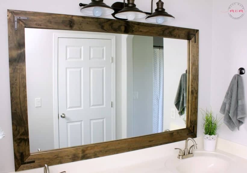 A bathroom with a wooden mirror and sink.