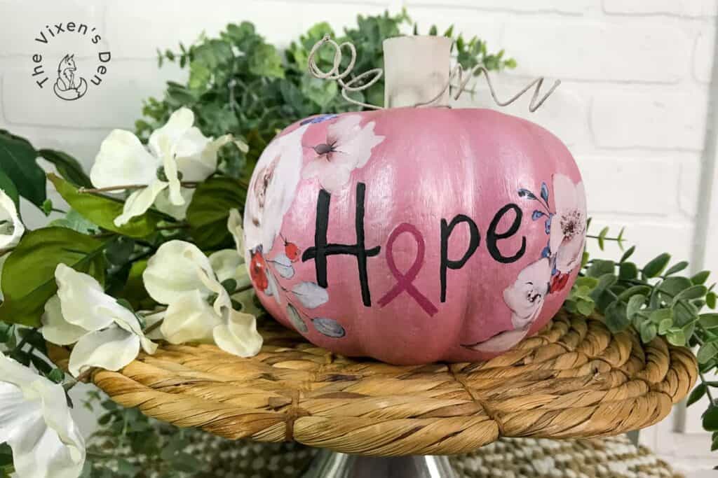 A pink pumpkin with the word hope painted on it.