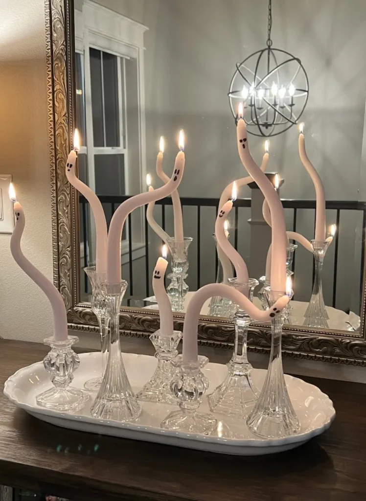 A tray of candles on a table with a mirror.