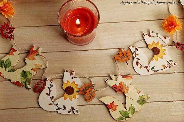 A wooden table with fall decorations and a candle.