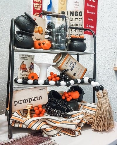 A display of pumpkins and other items on a tiered tray.