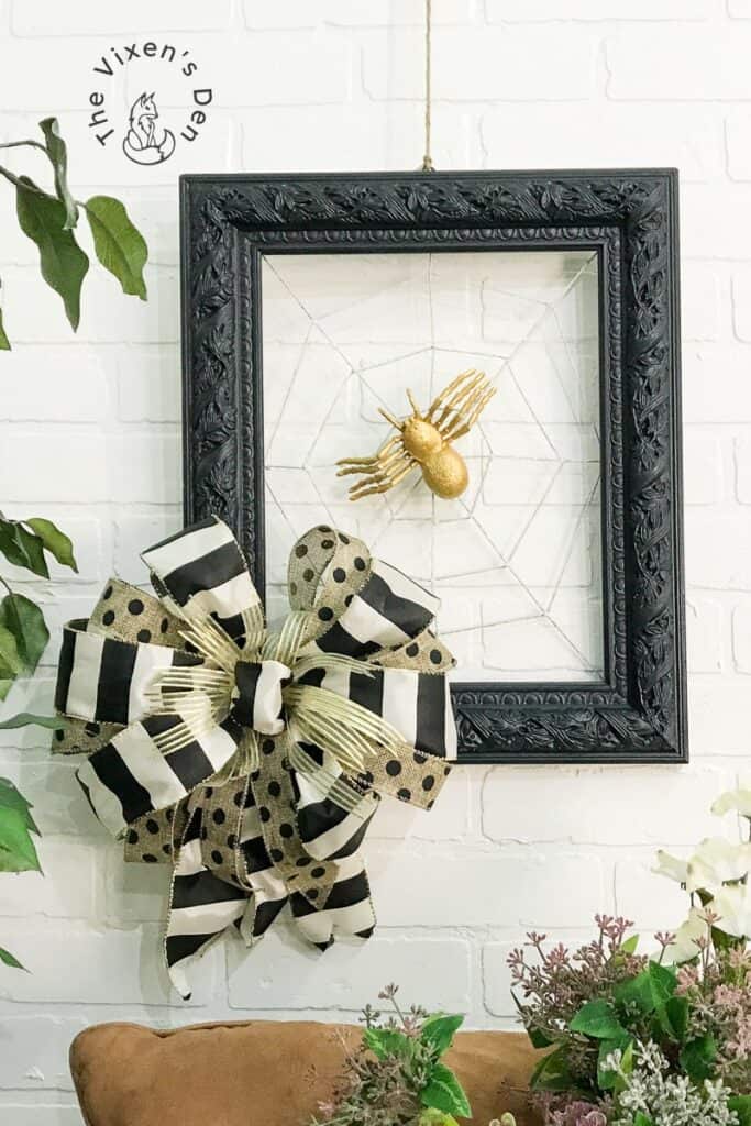A black and white spider web wreath hanging on a wall.
