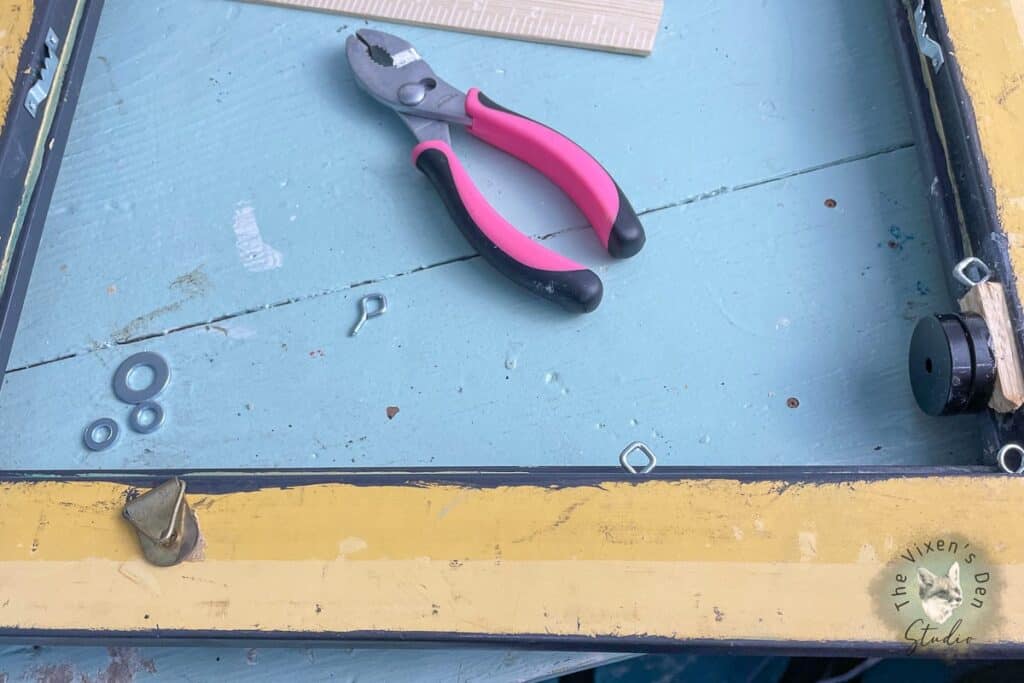 A pair of pink pliers on top of a yellow frame.