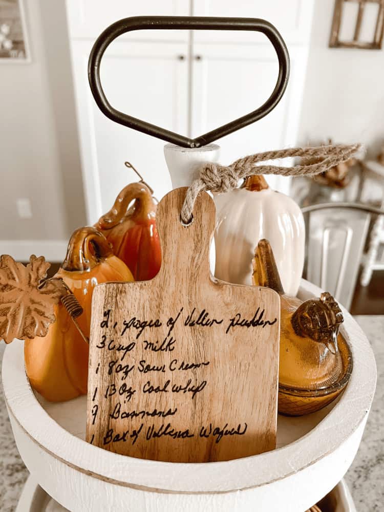 A wooden cutting board with a recipe written on it.