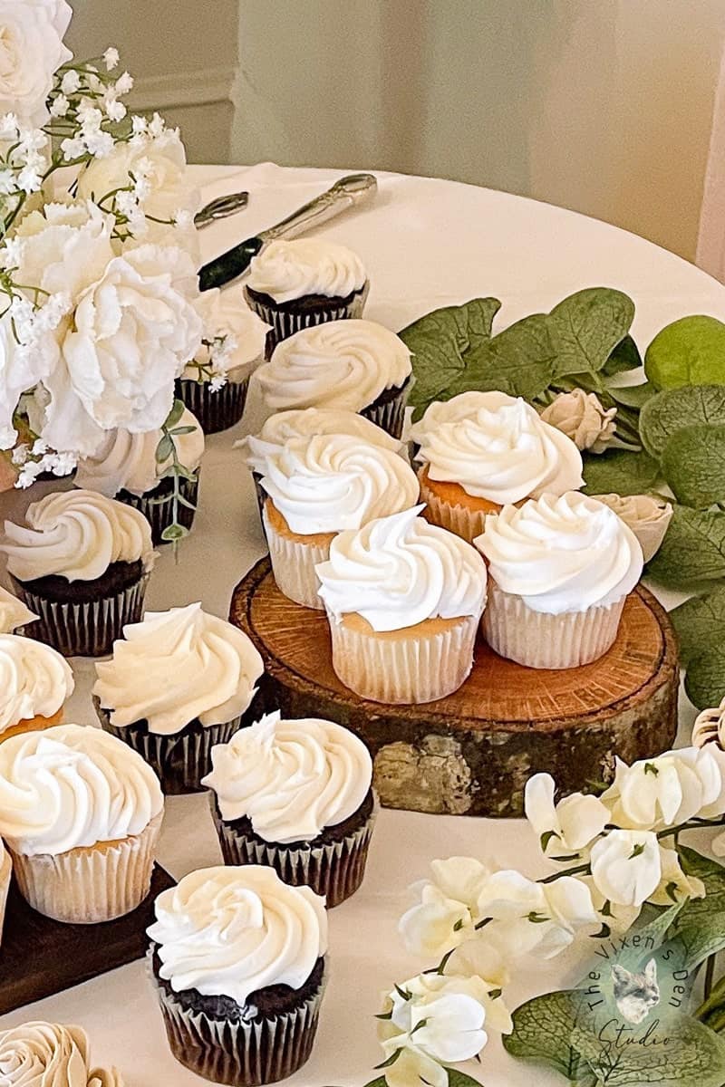 A table with cupcakes and flowers on it.