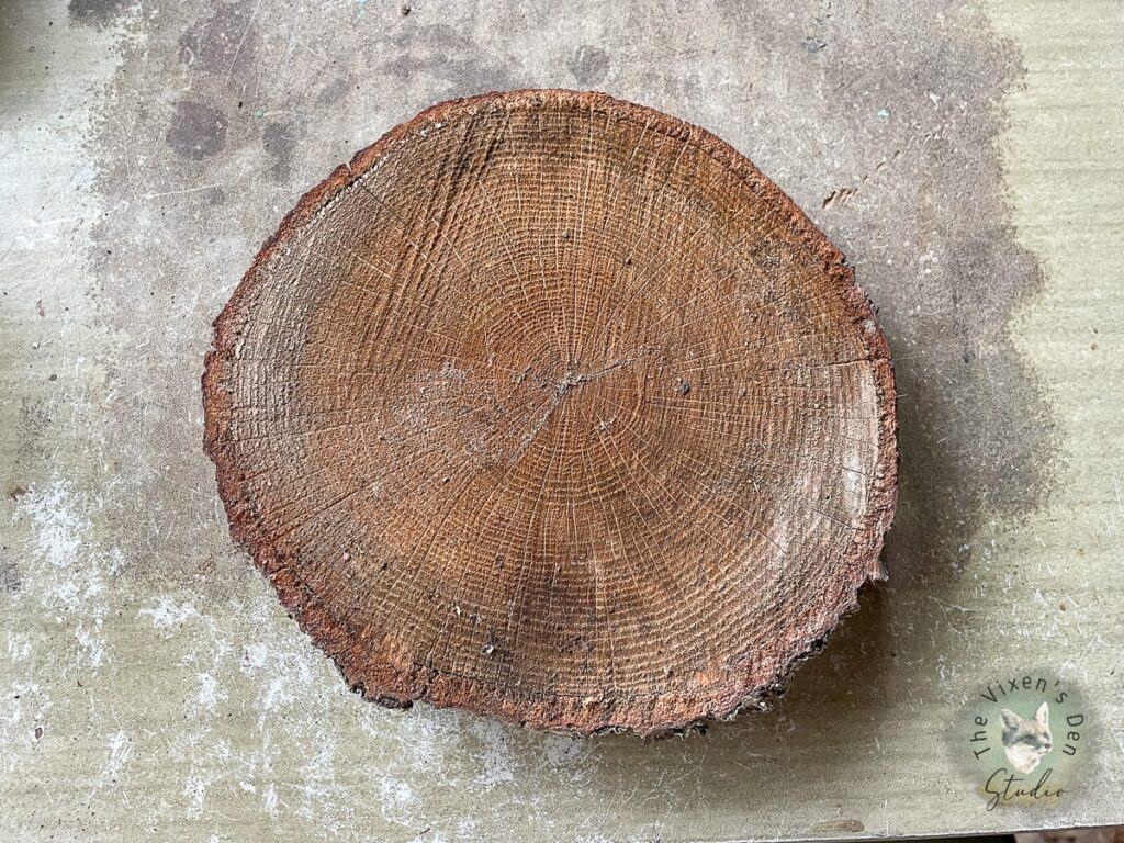 A slice of wood is sitting on top of a table.