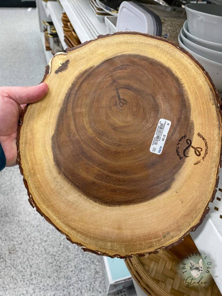 A person holding a piece of wood in a store.