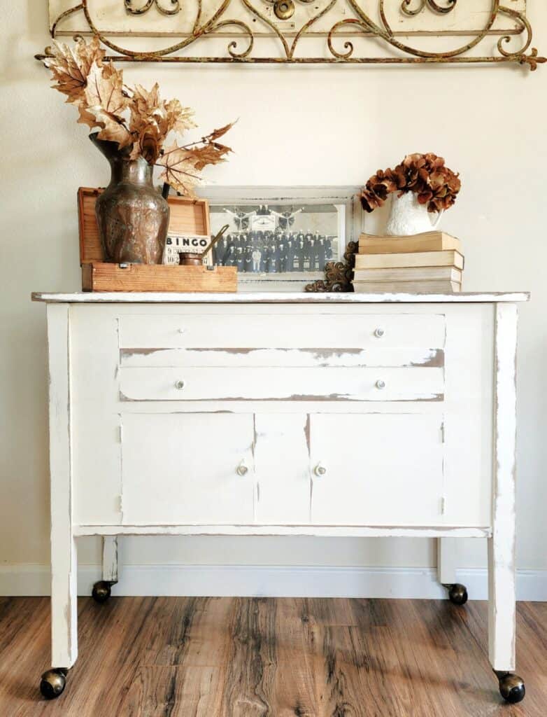 A white dresser with a vase on top.