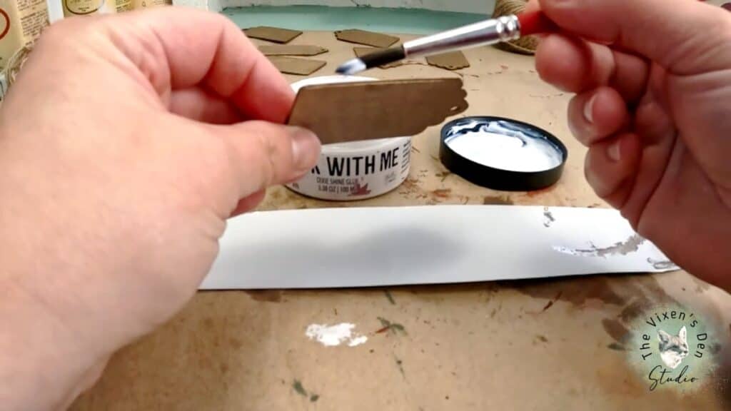 A person is using a paint brush to paint a piece of paper.